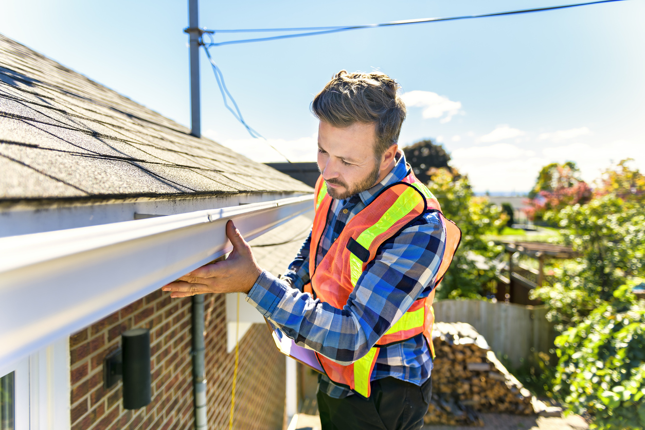 a man inspecting gutters